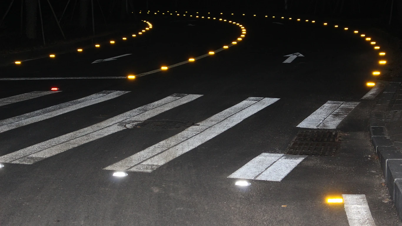 Road markers tracing a curve at night in a supplied application photograph